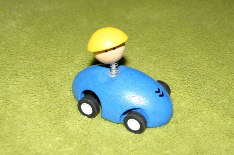 Spielzeugauto auf grünem Teppich