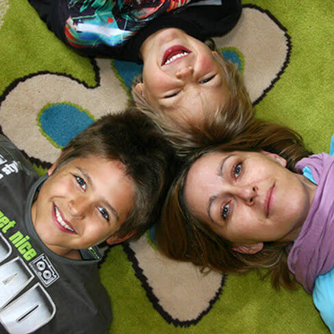 Frau mit 2 Jungen auf Teppich